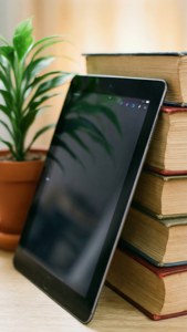 A tablet on books with a plant, study and education theme.